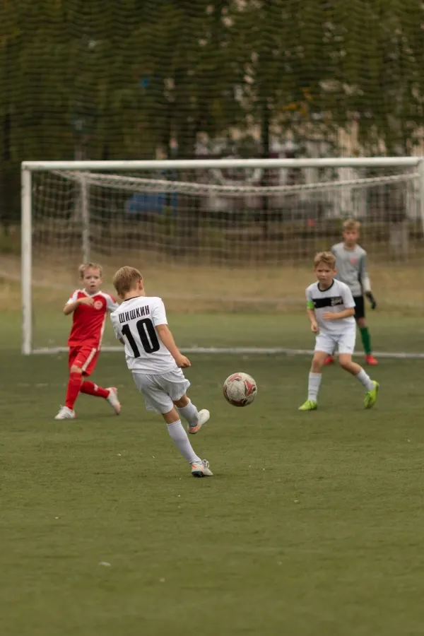Youth soccer match, number 10 striking the ball toward the goal
